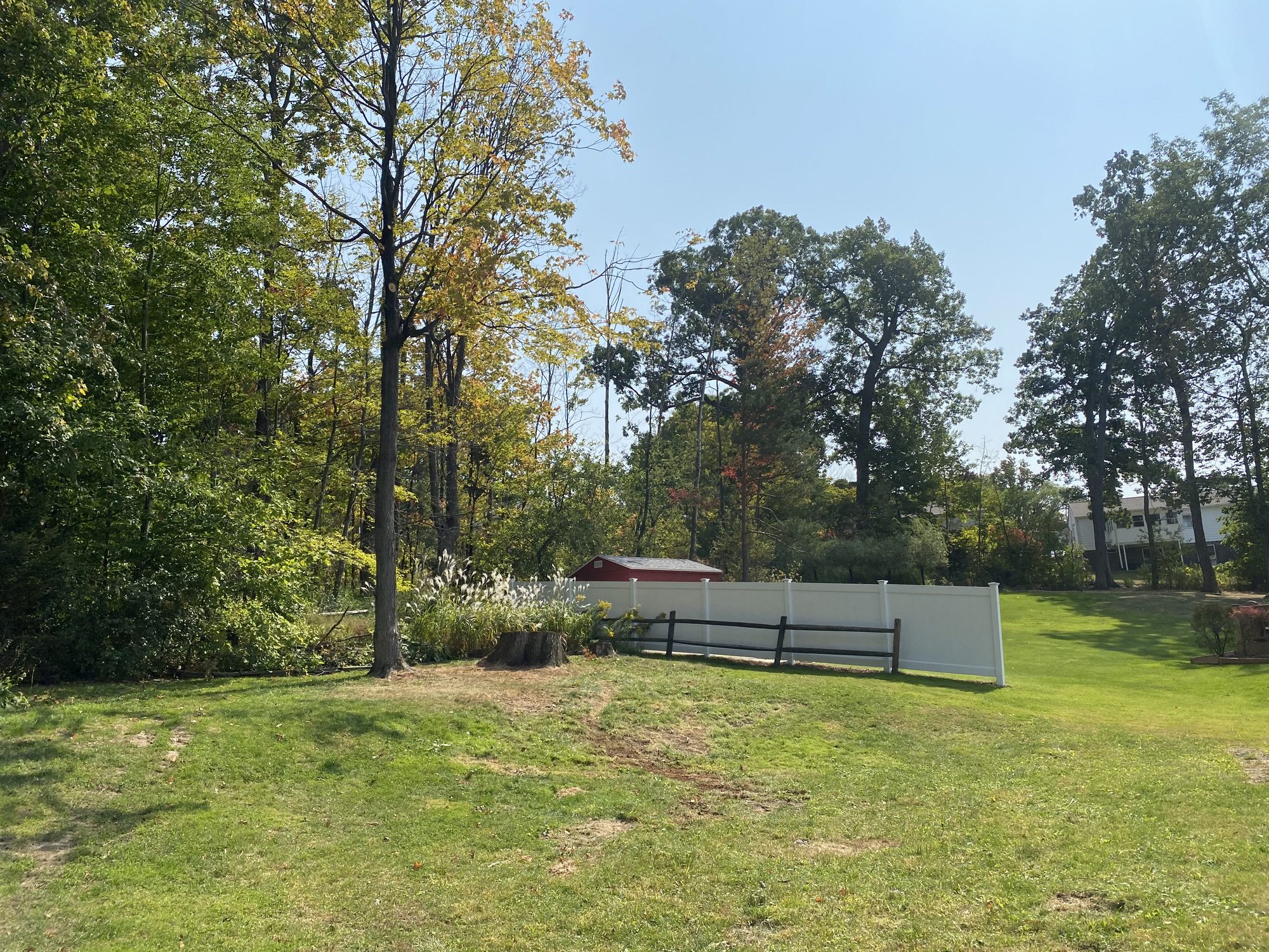 An open, cleared and graded lawn bordered by a fence
